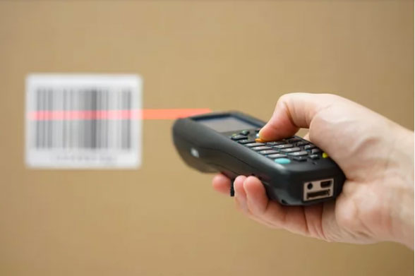 A worker scanning a package with a handheld barcode scanner
