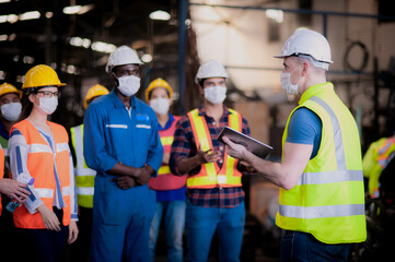 Manufacturing employees working at a bench wearing face masks